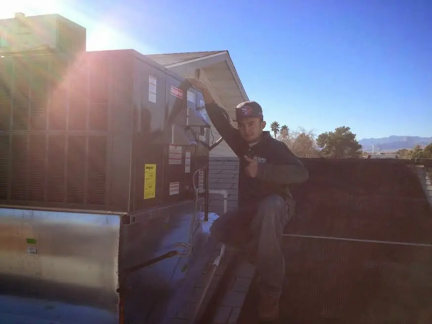 HVAC technician performing Air Duct Cleaning on a rooftop unit in Carmel